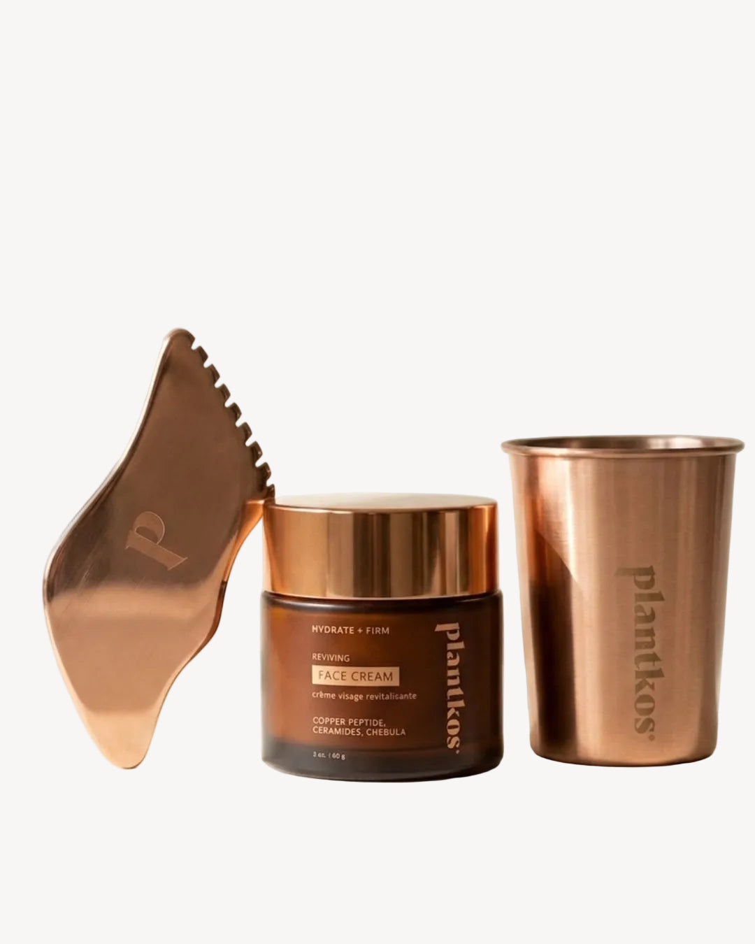 Copper-themed skincare products including a jar, cup, and tool on a light background